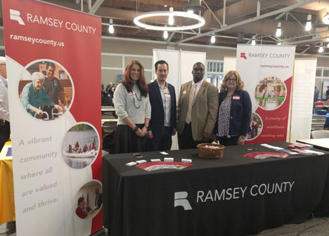 Procurement staff behind table at fair