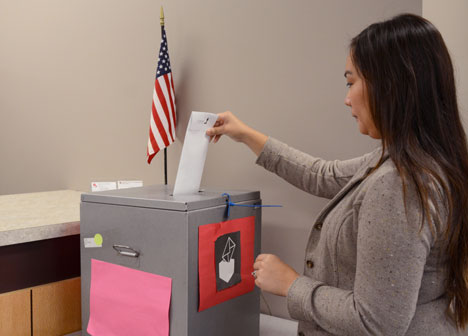 Woman places ballot in early voting box