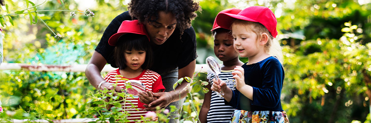 image: Adult in a garden with three children.