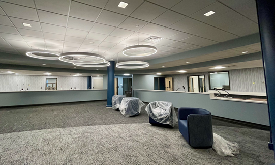 Newly renovated Downtown Service Center lobby featuring modern lighting, service counters, and furniture—set to reopen June 16, 2025, with expanded services and an upgraded layout