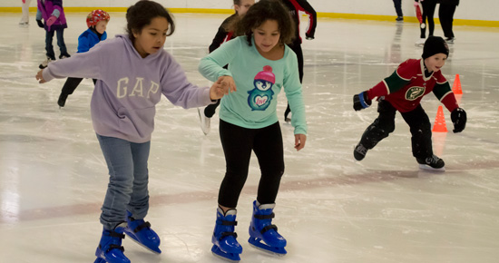 Two young girls skating at Aldrich Arena Two young girls skating at Aldrich Arena