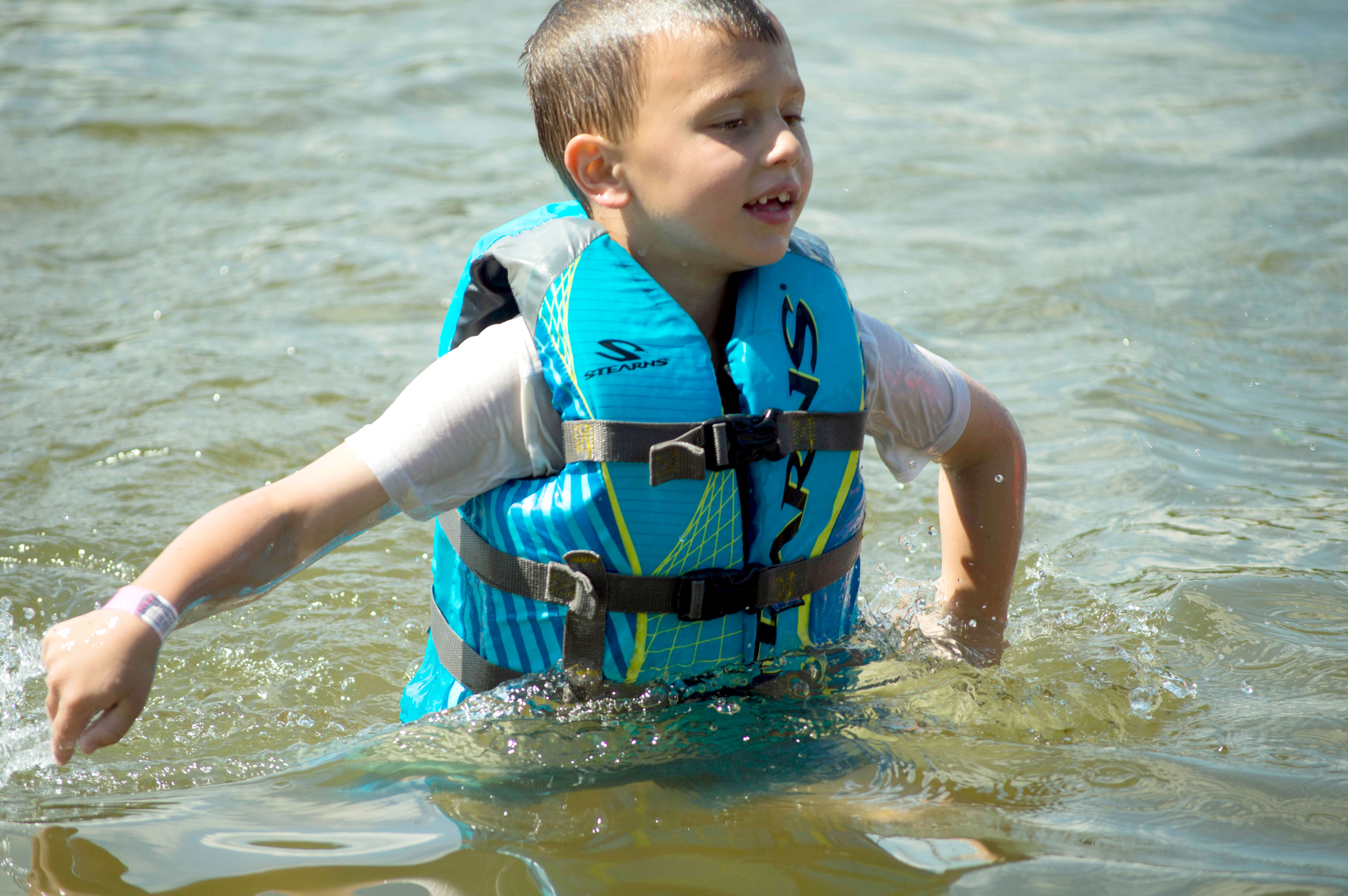 Boy wearing a life jacket swimming in Snail Lake.