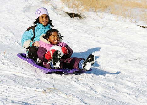 Two young girls on a sled