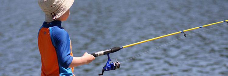 Boy with a fishing pole at a lake