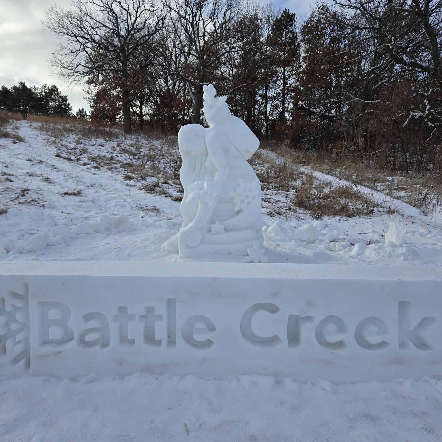 Snow sculpture of a woman kneeling in the snow at the Ramsey county Battle Creek Winter Recreation.