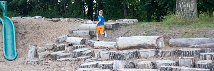 Boy running through the Lake Owasso nature play area