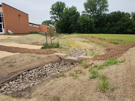 Stormwater filled with rocks on the side of a building