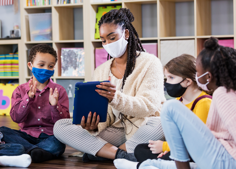 Group of preschool students in circle wearing cloth face masks