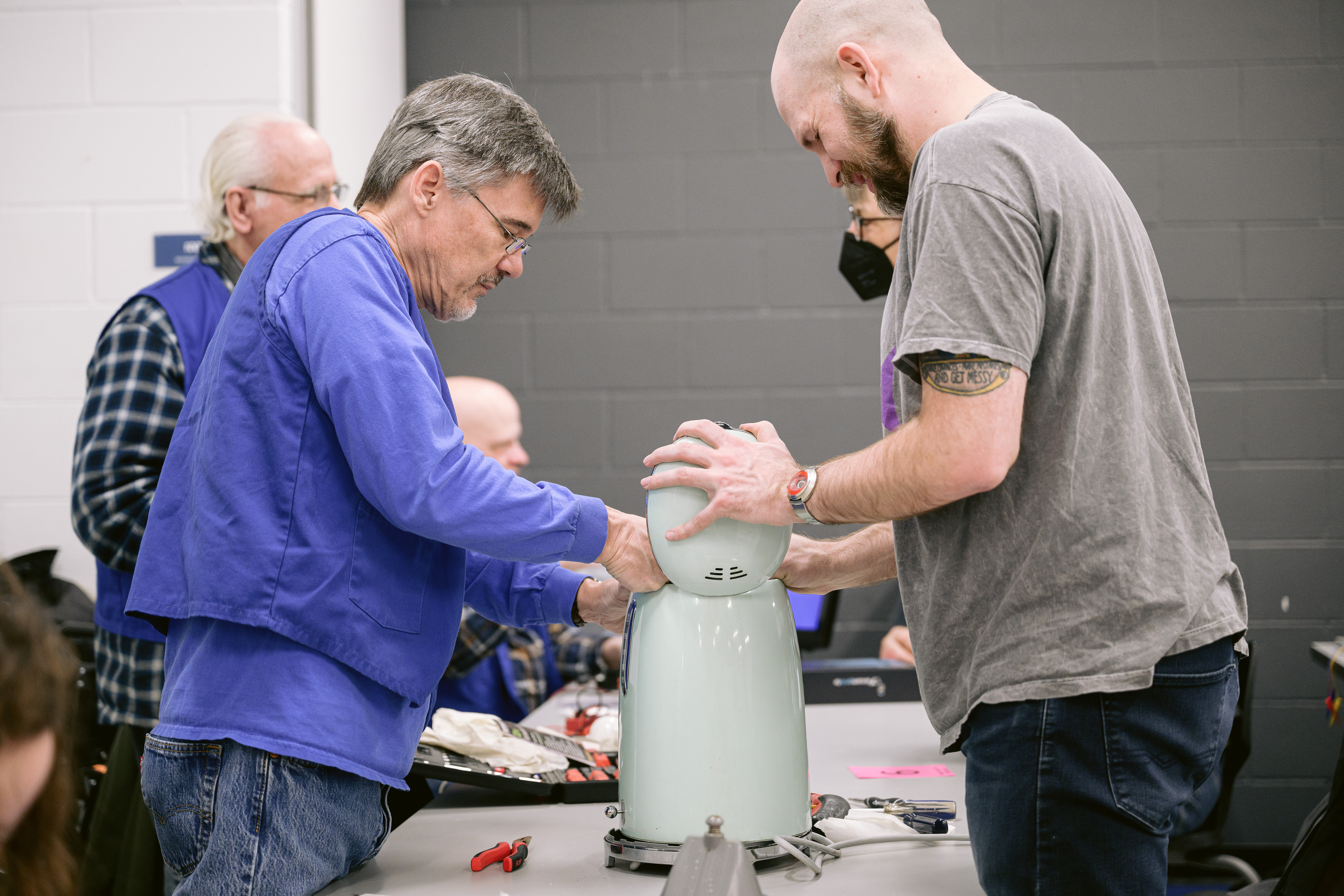 Volunteer and participant fixing an electric kettle together