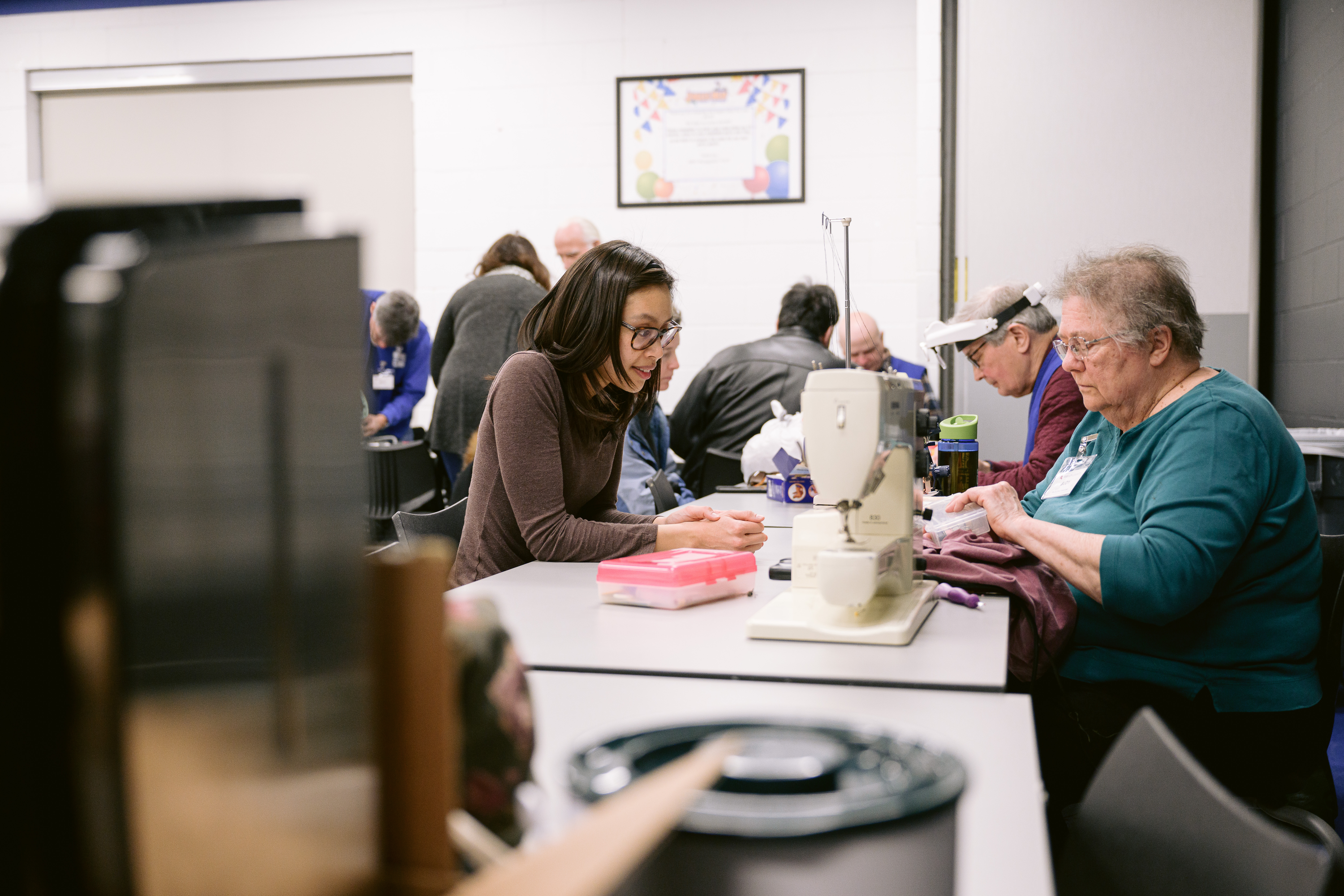 Volunteer and participant mending an item of clothing together
