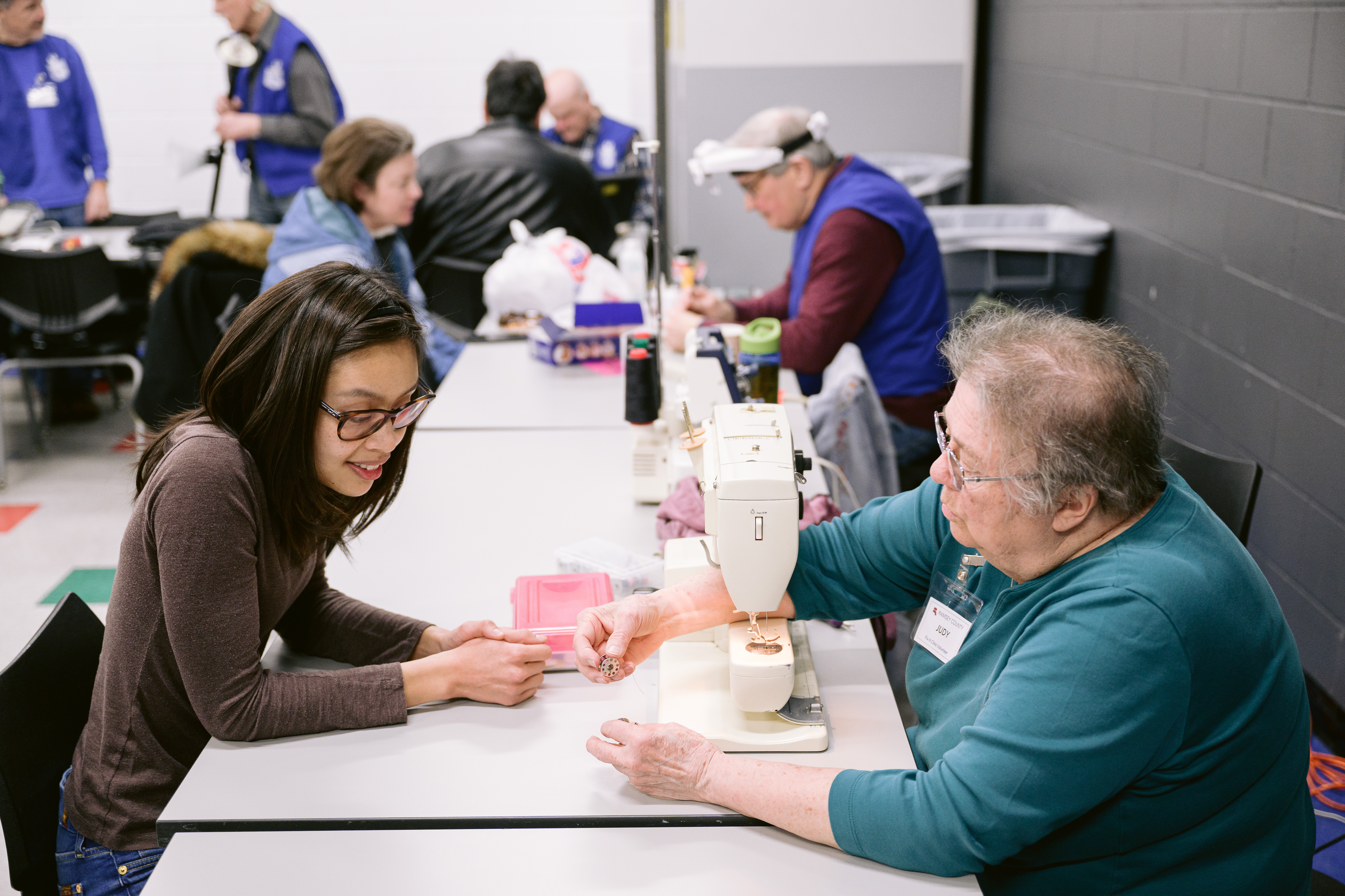 Mender helping resident repair clothing