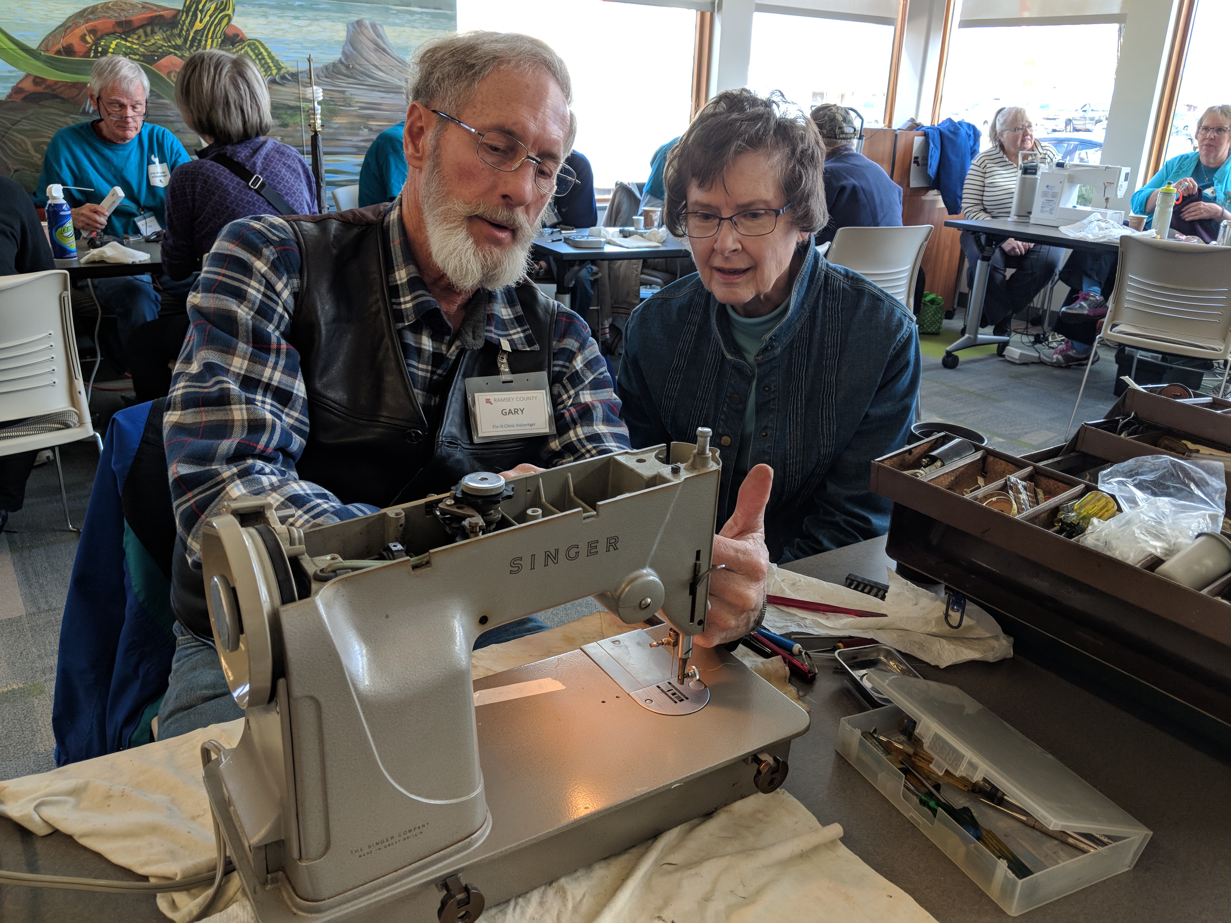 Fixer helps a resident fix their sewing machine