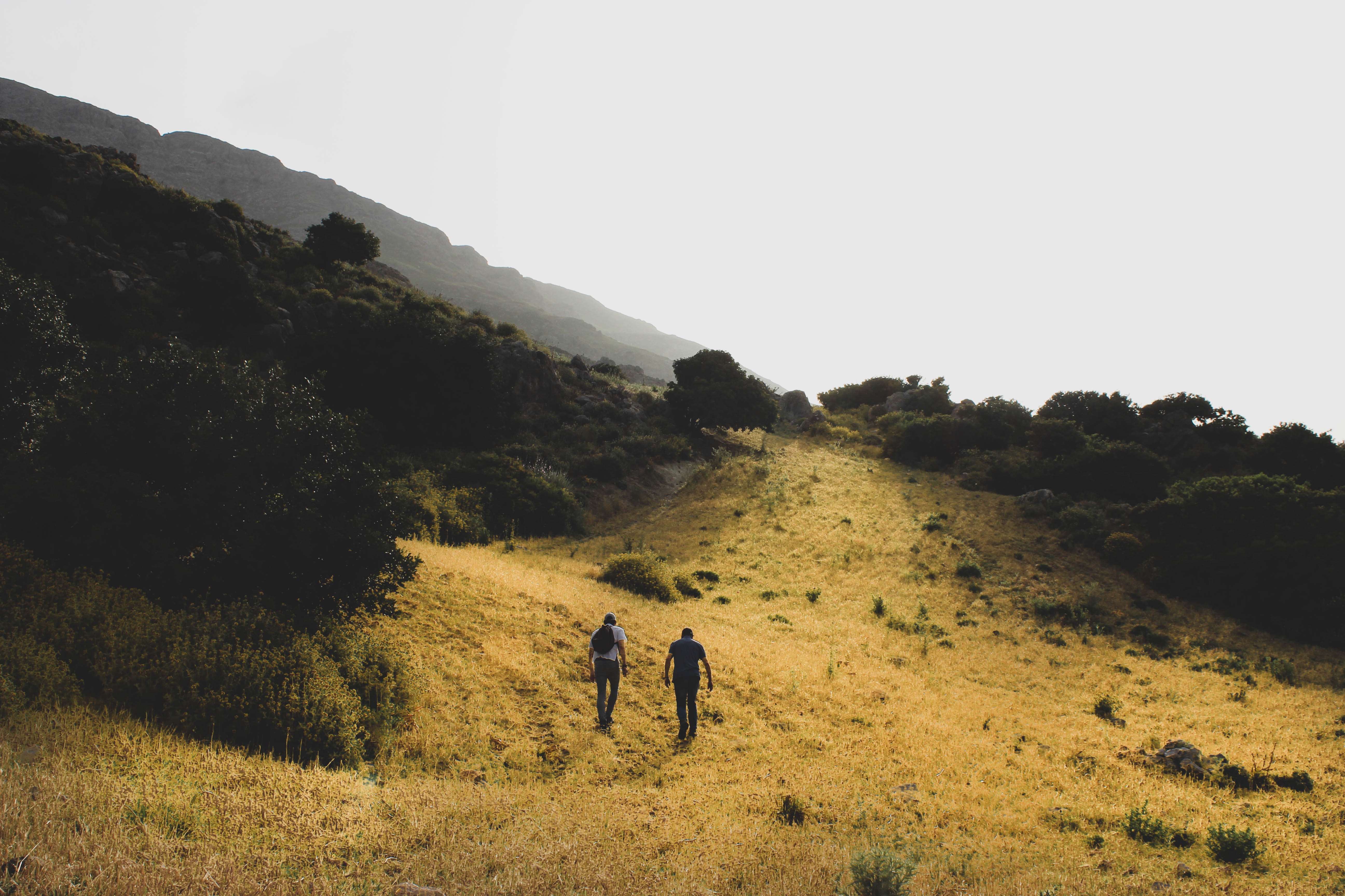 Two people walking up a hill