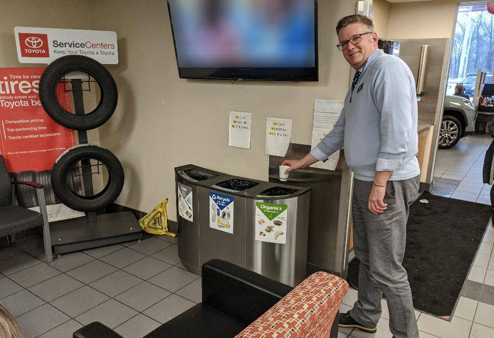 Man recycling a coffee cup at Maplewood Toyota