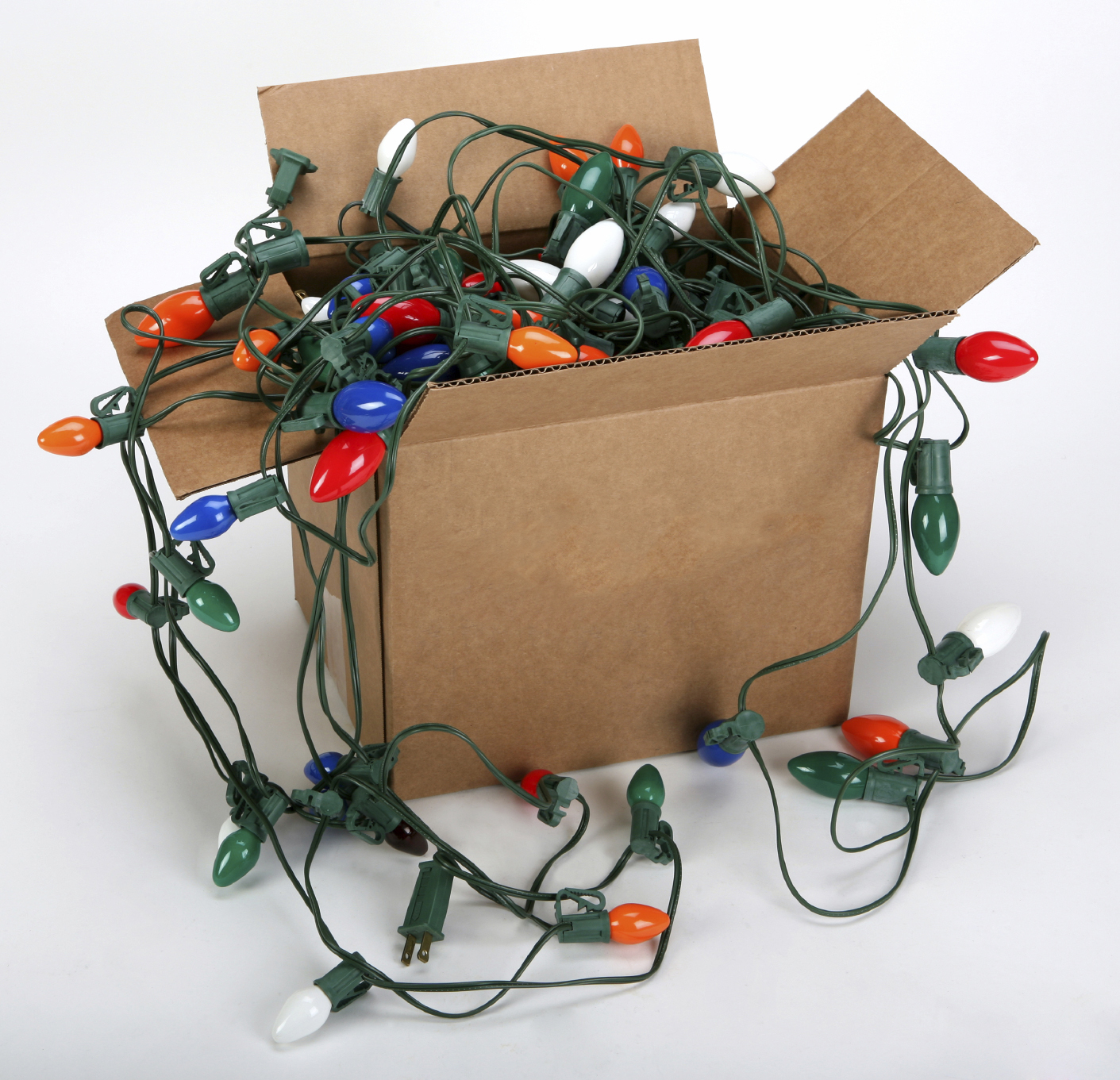 Holiday trees, lights and cords in a cardboard box