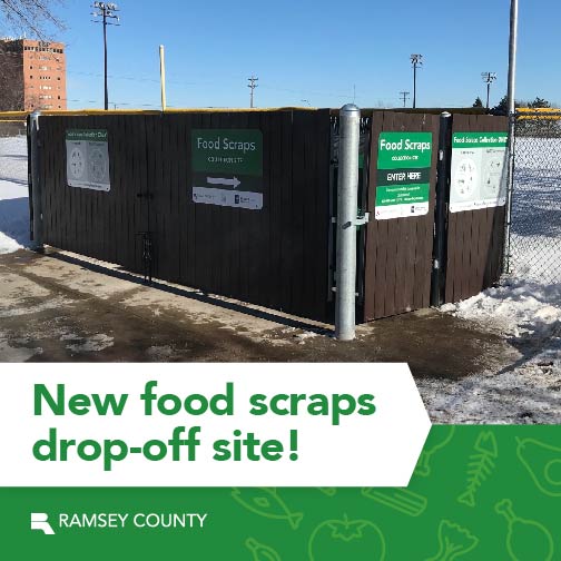 A chain link fence enclosure with green signs on it that read "food scraps"