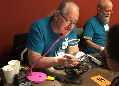 Fix-It Clinic volunteer helps repair fan