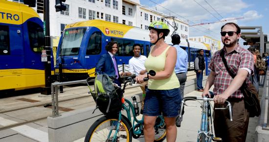 people on bikes and walking on light rail platform