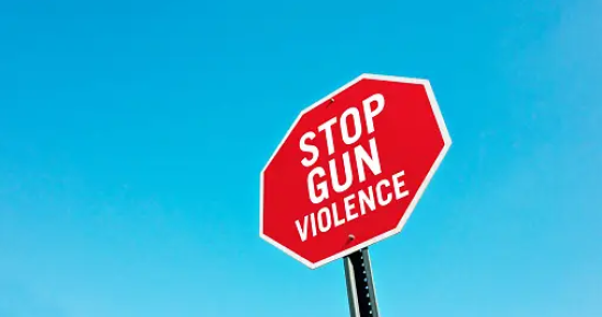 Image of stop sign with "stop gun violence"
