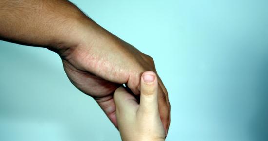 Adult and child hands holding
