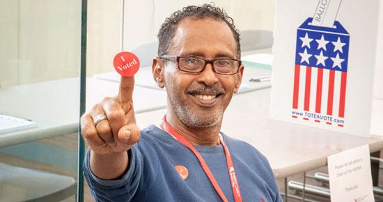 Election judge holding up "I Voted" sticker