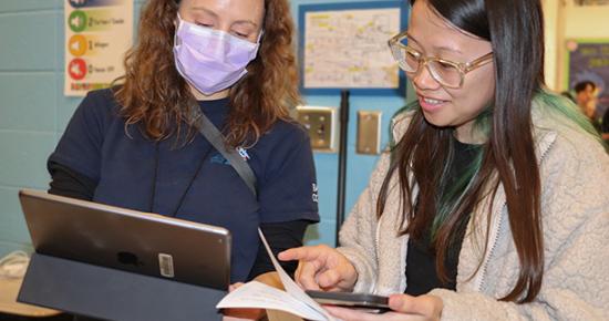 A white woman and asian woman discuss health forms at a flu clinic lead by the Medical Reserve Corps of Ramsey County
