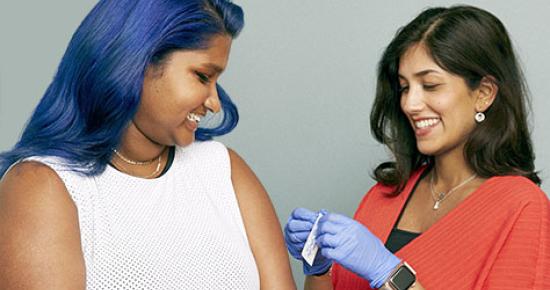 Young femme adult looks at care provider as care provider prepares to give them a vaccination by SELF Magazine and the American Association of Pediatrics