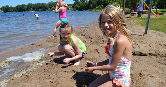 Girls playing in sand at beach Girls playing in sand at beach