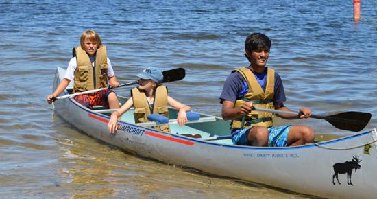 Children smiling in a canoe on Snail Lake