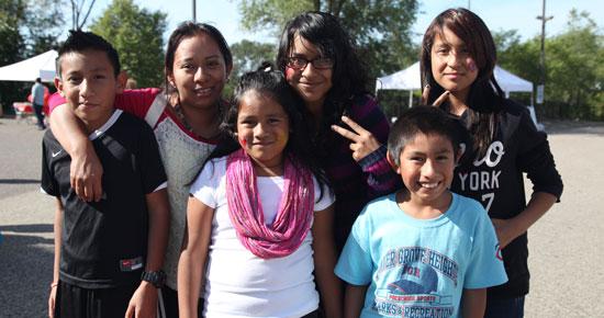 Group of children at community event embracing and smiling