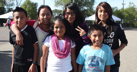 Group of children at community event embracing and smiling