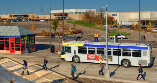 Bus arriving at transit center with pedestrians