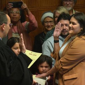 A judge administering the oath of office to Kelly Miller.